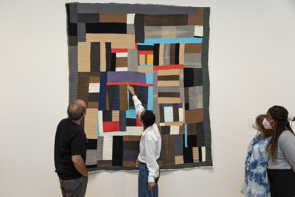 Interns examine a Gee's Bend quilt with a curator