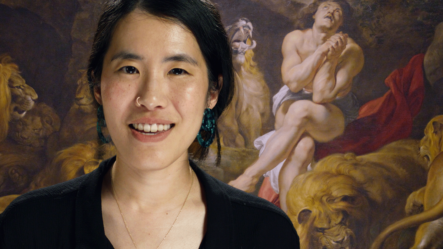 A photograph of a woman in front of Peter Paul Rubens' Daniel in the Den of Lions