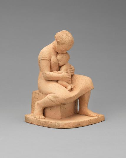A sculpture of a woman holding a small child in her lap.