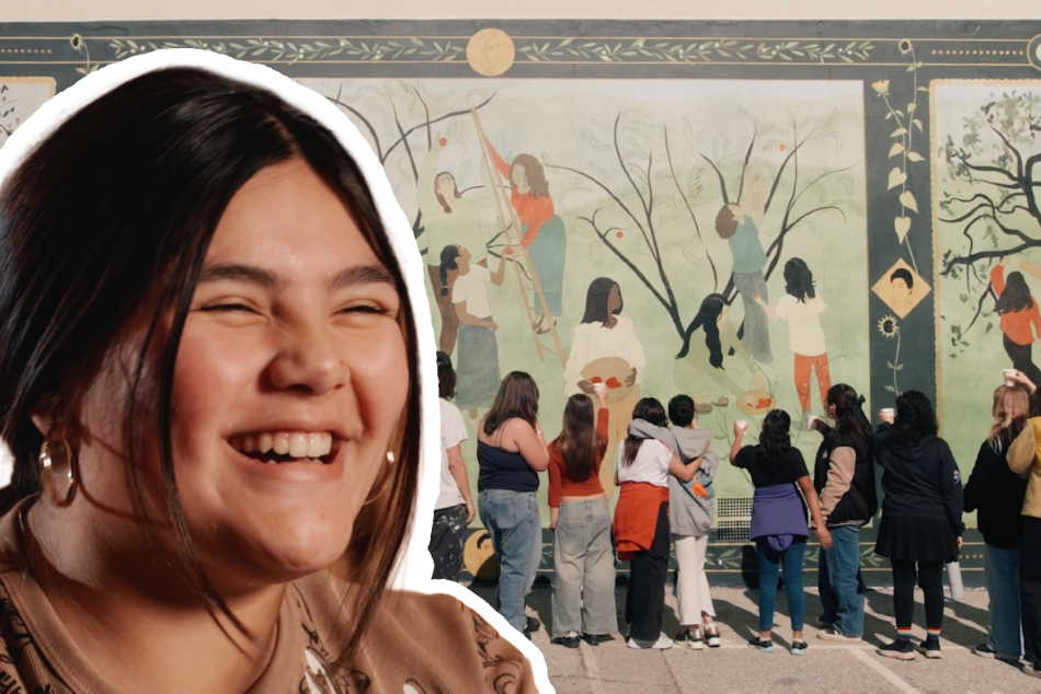 A student smiles in front of a painted mural at Altadena Elementary School