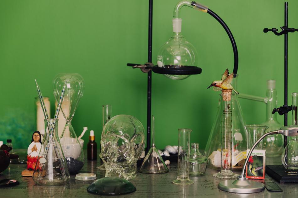 A photograph shows a skull, scientific materials like test tubes, and other small objects.