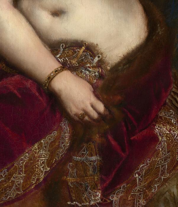 A close up of Venus's red velvet cloak trimmed with metallic embroidery