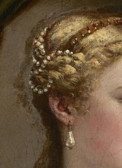 A close up of pearls running through Venus' braids and dangling on her ear